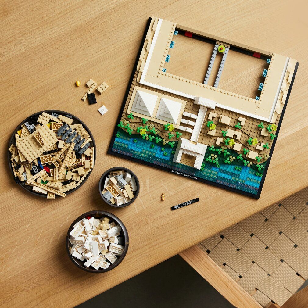 Lego-Set auf Tisch. Teile in Schalen. Zusammengebautes Modell eines Gebäudes mit Pyramiden.