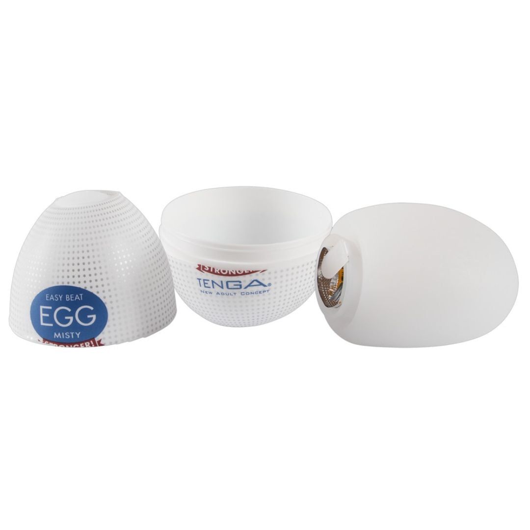 Drei Teile eines weißen, eiförmigen Produkts. Auf der Verpackung steht "TENGA" und "EGG MISTY".