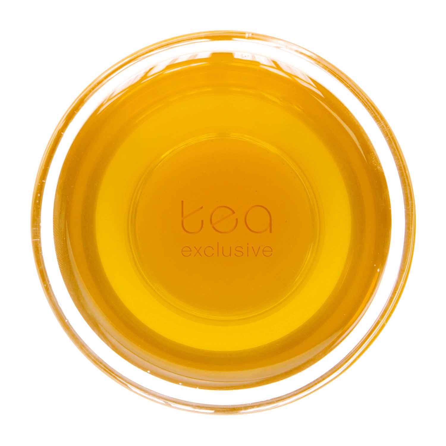 Glas mit goldfarbenem Tee. Aufschrift: tea exclusive.