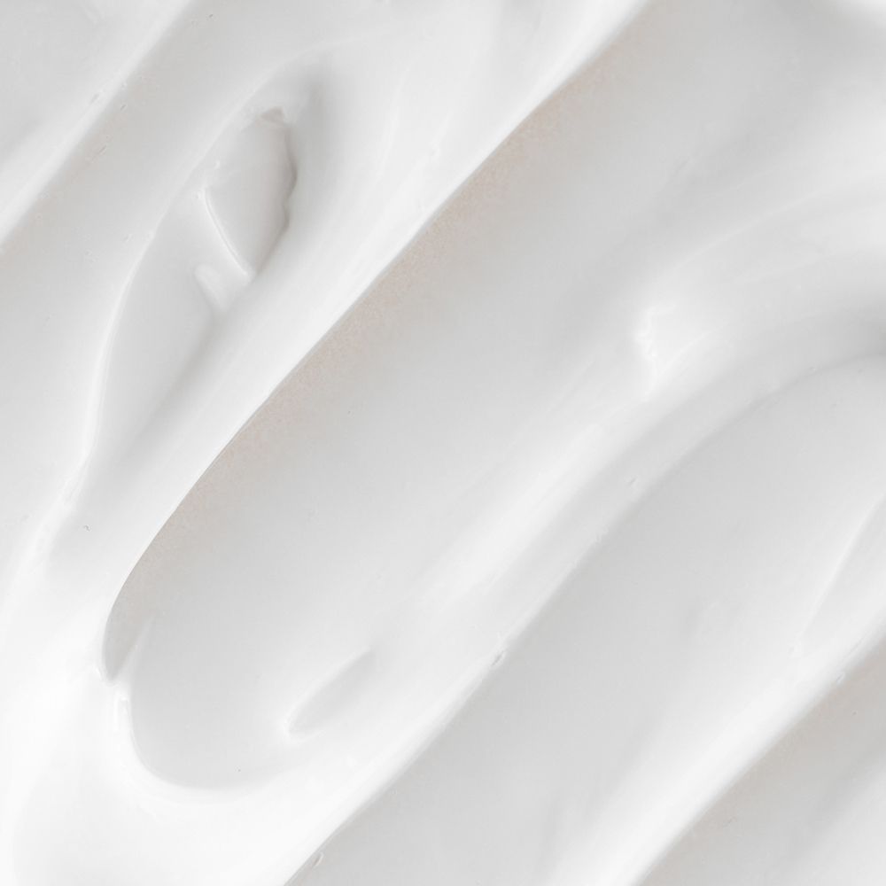 Nahaufnahme von weißer Creme, wellenförmig angeordnet.