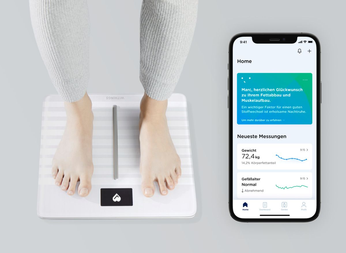 Person steht auf weißer Waage. Smartphone zeigt App-Daten. Grauer Hintergrund.
