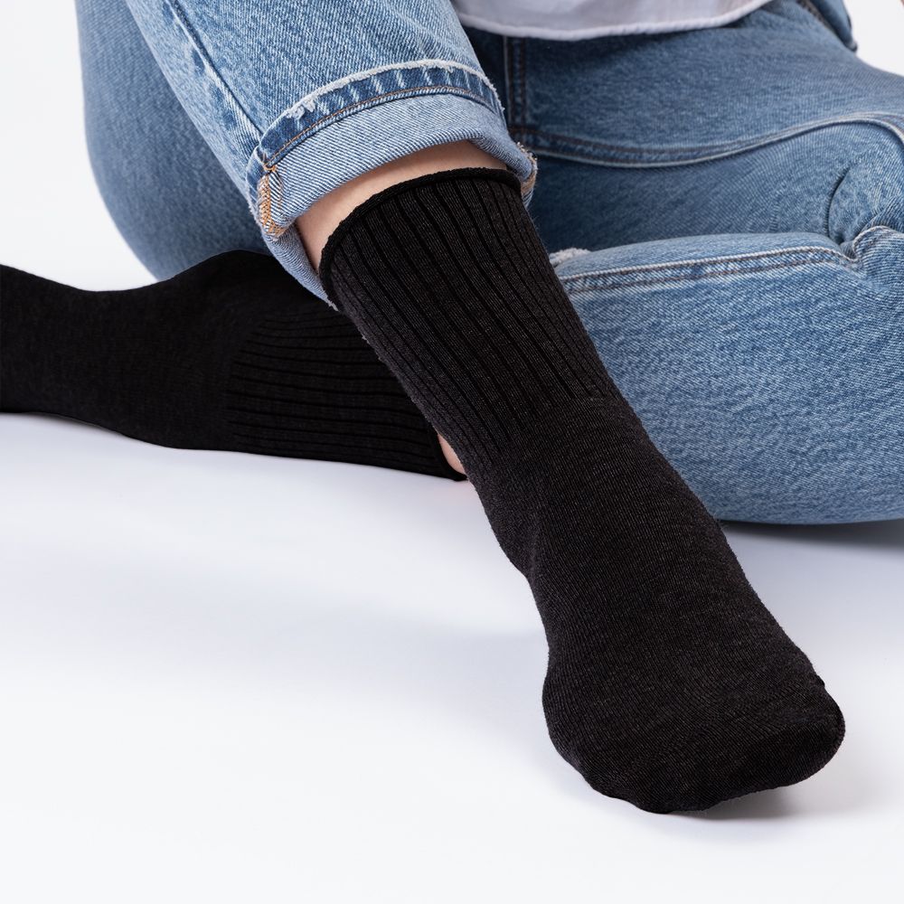 Schwarze Socken ohne Gummibund, Nahaufnahme der Füße einer Person.