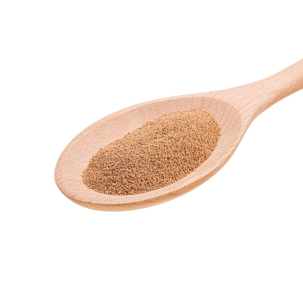 Holzlöffel mit braunem, gemahlenem Produkt. Nahaufnahme, isoliert auf weißem Hintergrund.