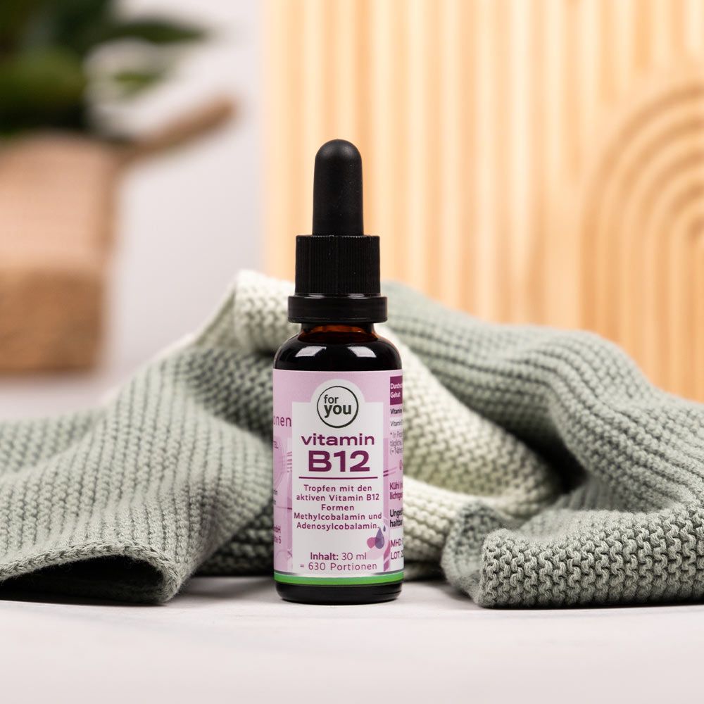 Flasche mit Pipette. Etikett mit "for You" und "Vitamin B12". Auf Textil gelegt.