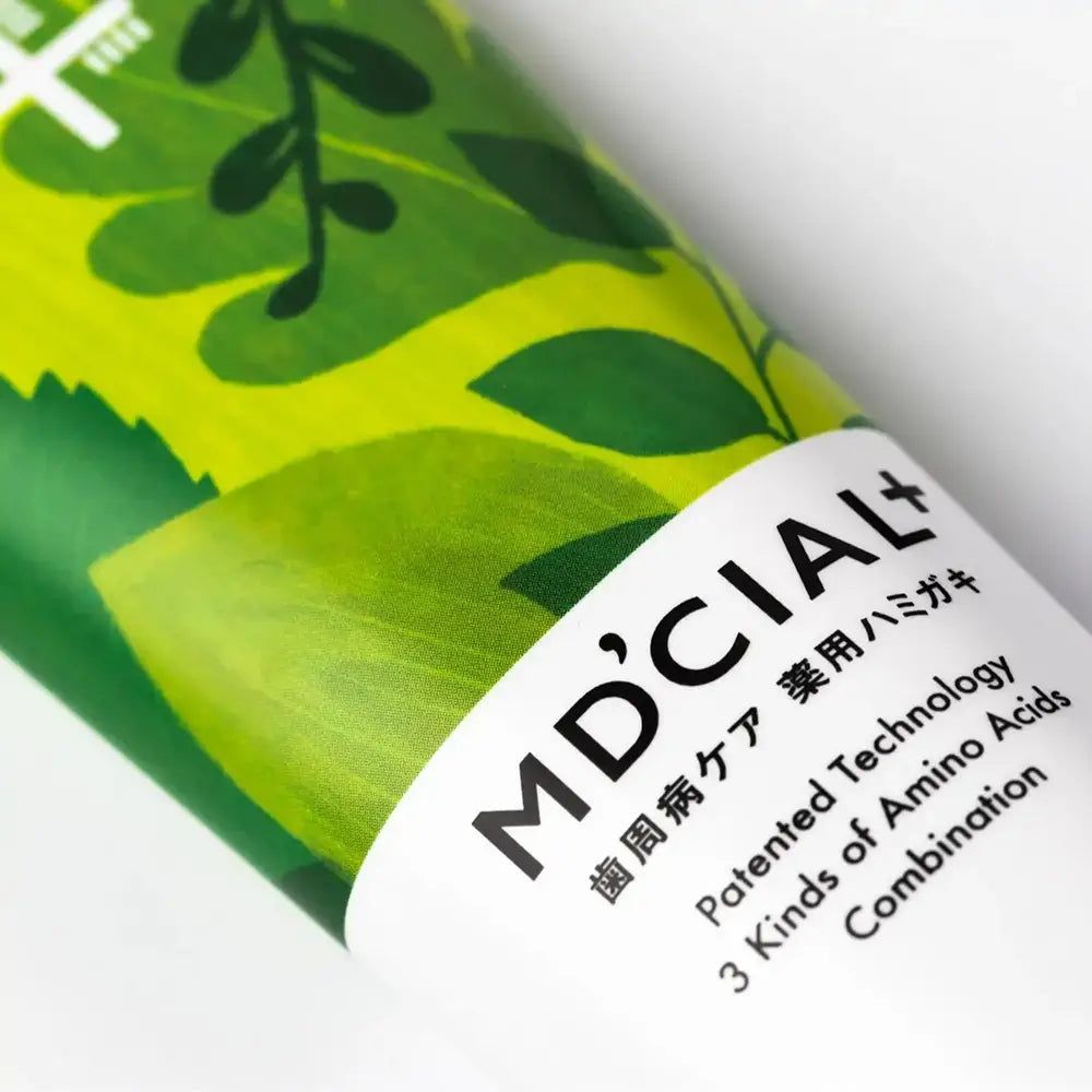 Nahaufnahme der MD'CIAL+ Zahncreme-Tube. Grünes Design, Schriftzug. Aufschrift: Patented Technology, 3 Kinds of Amino Acids.