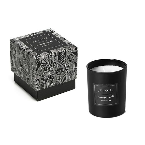 Schwarze Kerze und Verpackung. Verpackung mit Muster. Aufschrift: JE JOUE, massage candle, Jasmine and Lily.