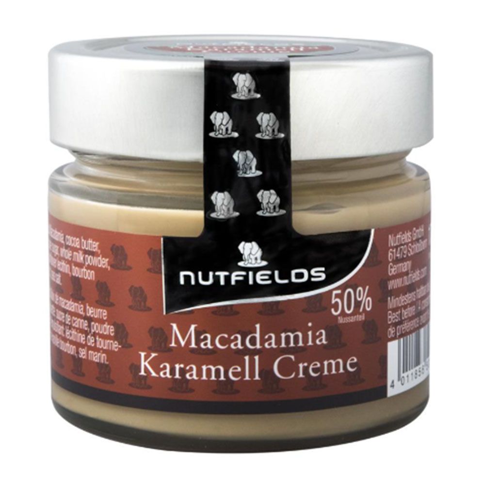 Glas mit Macadamia-Karamell-Creme. Etikett mit Produktname und Logo. Deckel mit Aufschrift. Braune Creme sichtbar.