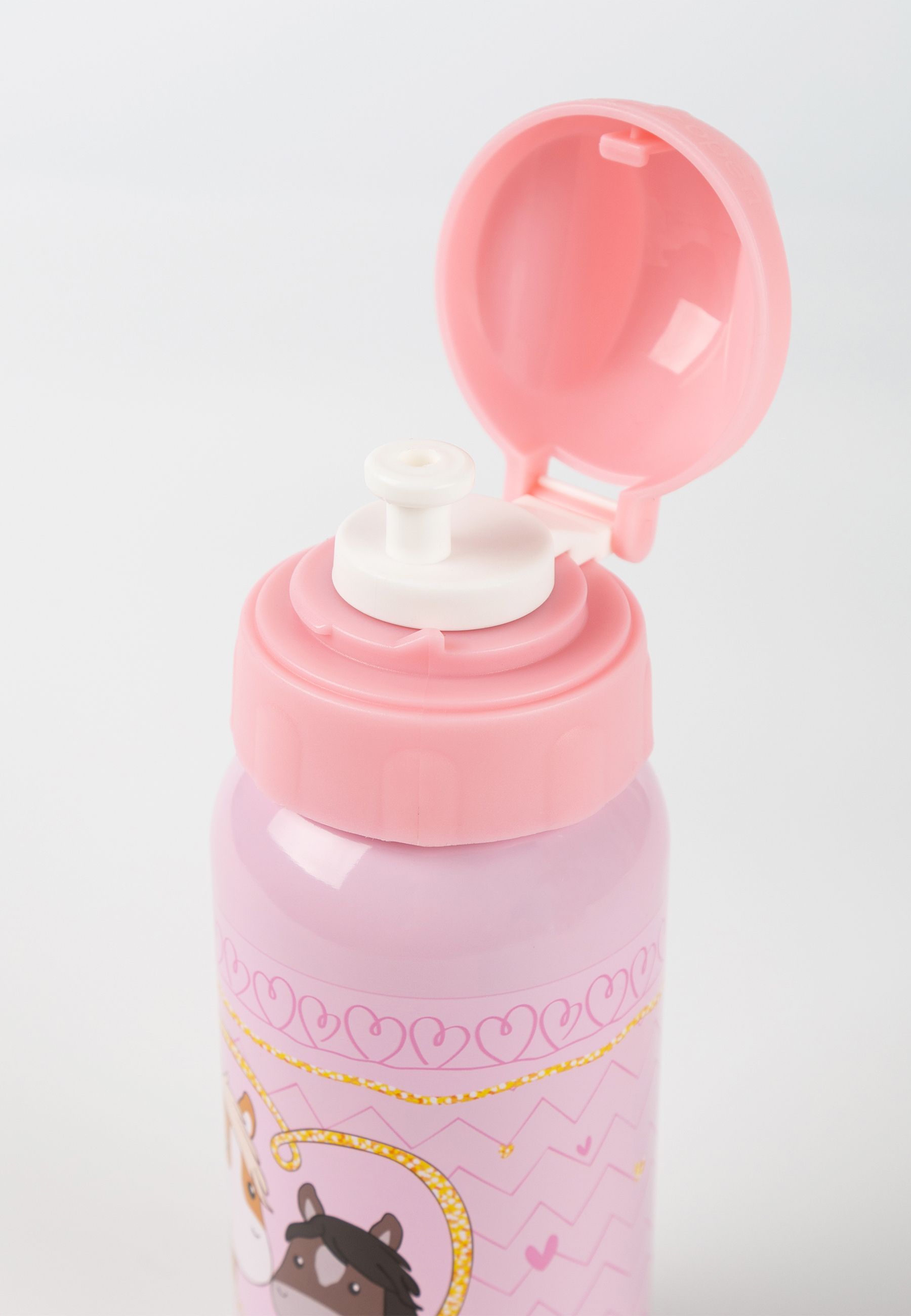 Nahaufnahme einer rosa Trinkflasche mit aufklappbarem Deckel. Weißer Verschluss. Herzmuster. Goldfarbene Akzente.