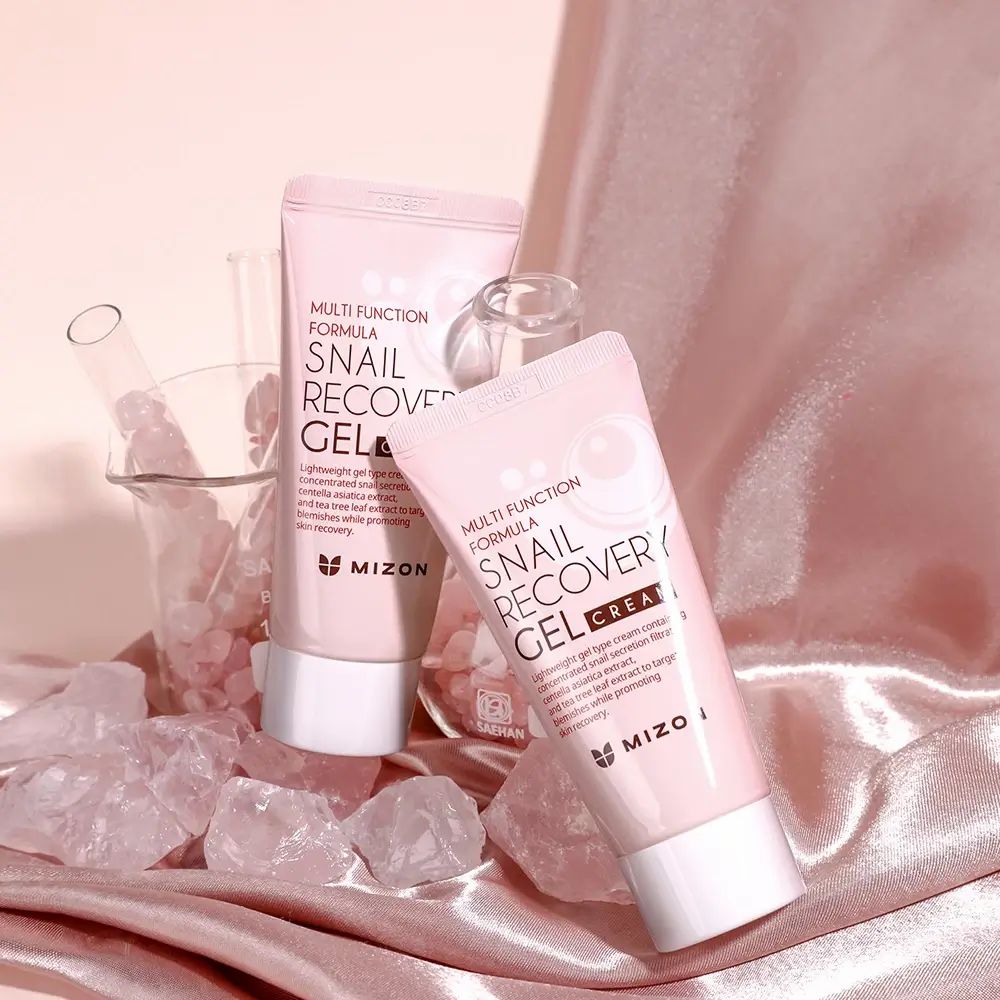 Zwei rosa Tuben mit Aufschrift: Snail Recovery Gel Cream, Mizon. Auf rosa Stoff. Text: Multi Function Formula.