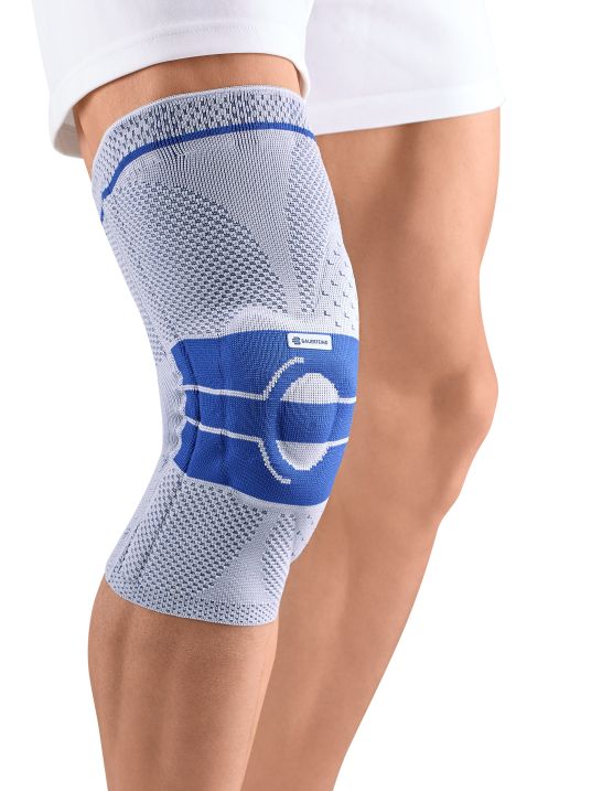 Kniebandage am Bein. Blaues Band mit BAUERFEIND-Logo.