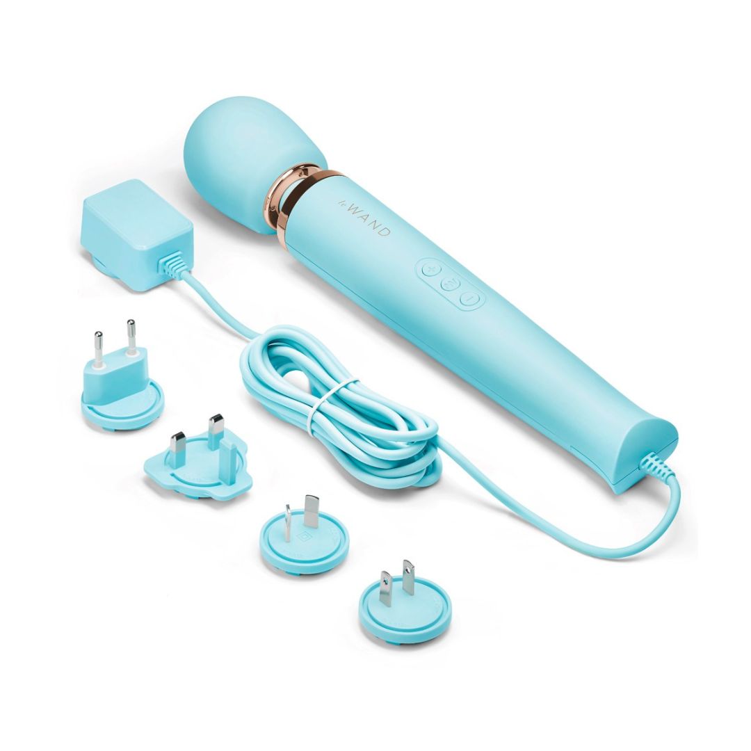 Hellblaues Massagegerät mit Netzteilen und Kabel. "Le Wand" ist auf dem Gerät sichtbar.
