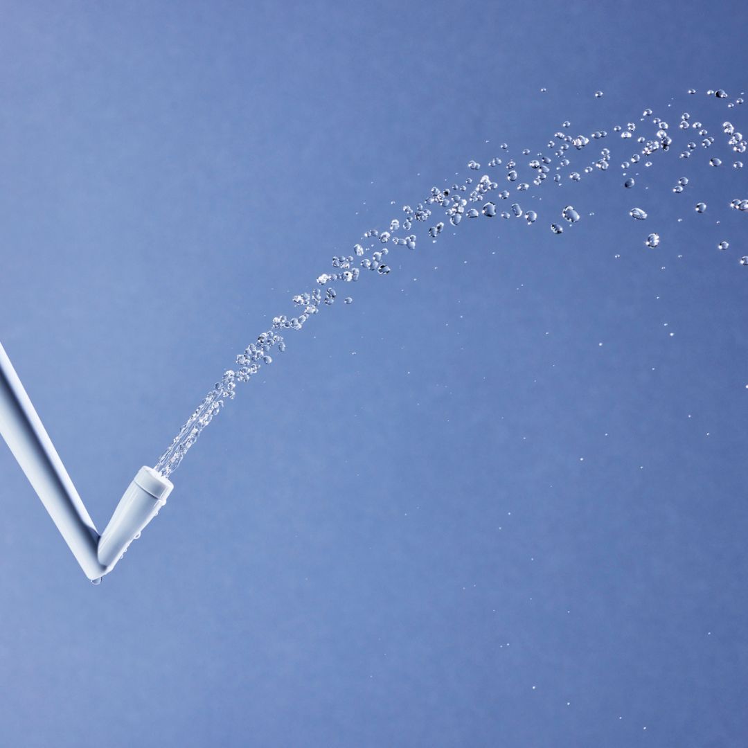 Nahaufnahme einer Intimdusche, Wasserstrahl sichtbar.