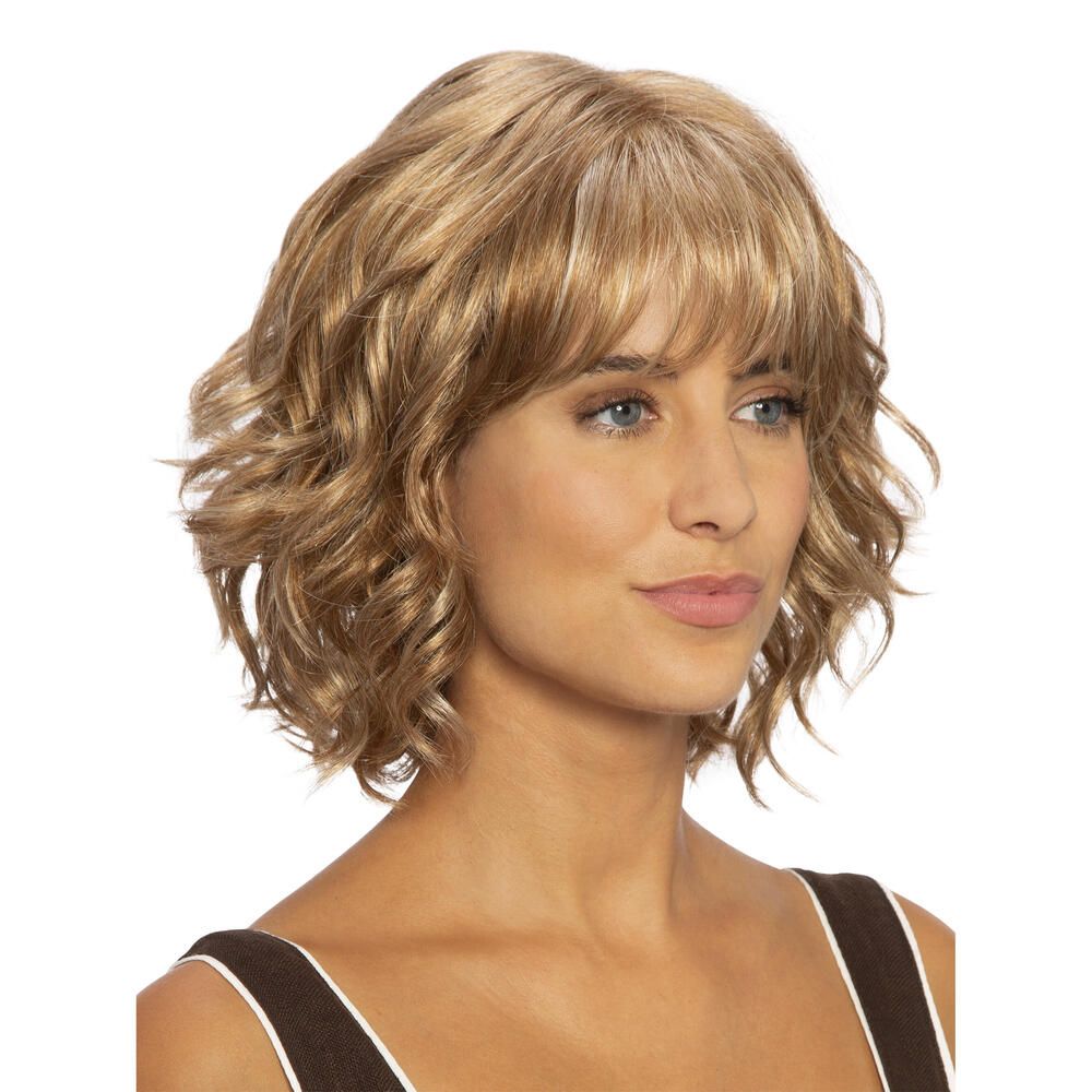 Perücke Capri, blond, gewellt, mit Pony. Frau mit Perücke vor weißem Hintergrund. Schulterlange Haare.