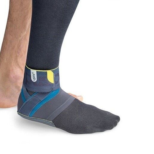 Knöchelbandage am Bein. Grau, blau und gelb. Das Produkt ist am Knöchel befestigt. Aufschrift 'push'.