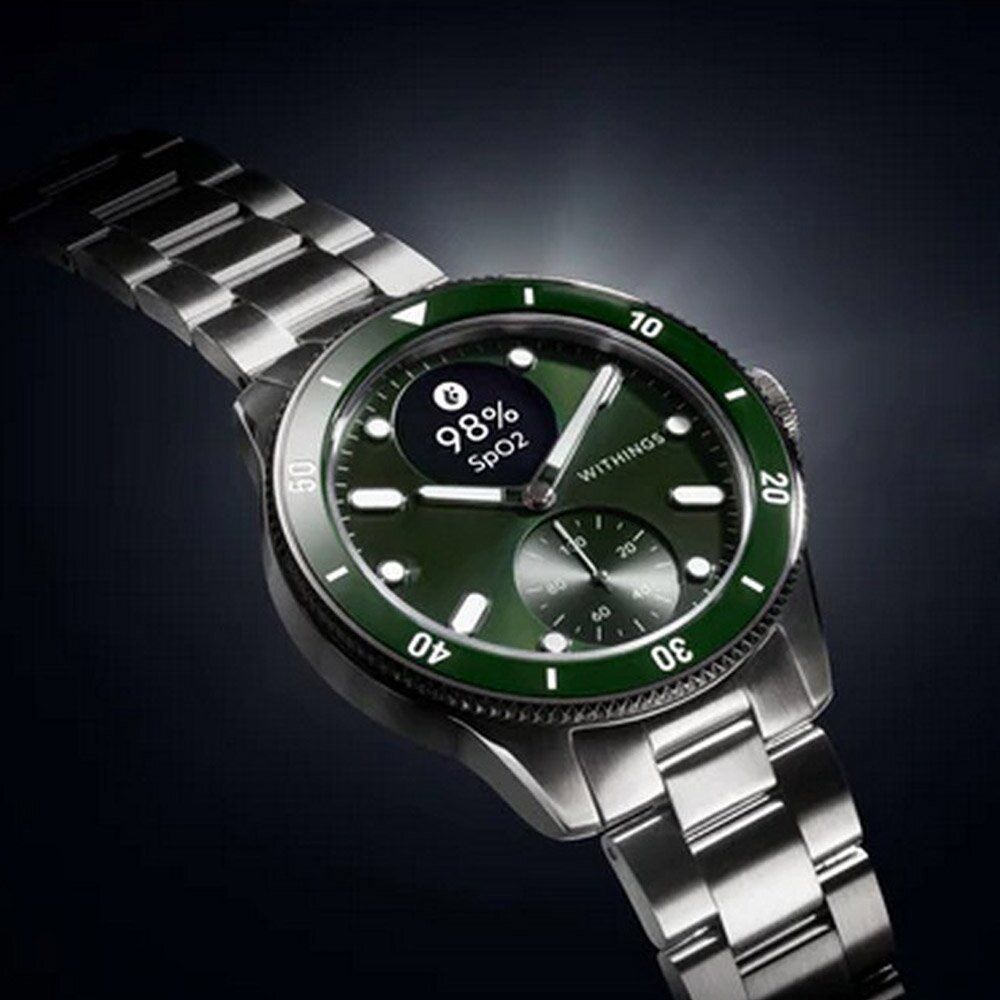 Grüne Smartwatch mit Edelstahlarmband. Zifferblatt mit SpO2-Anzeige und Withings-Logo. Lünette mit Zahlenmarkierungen.