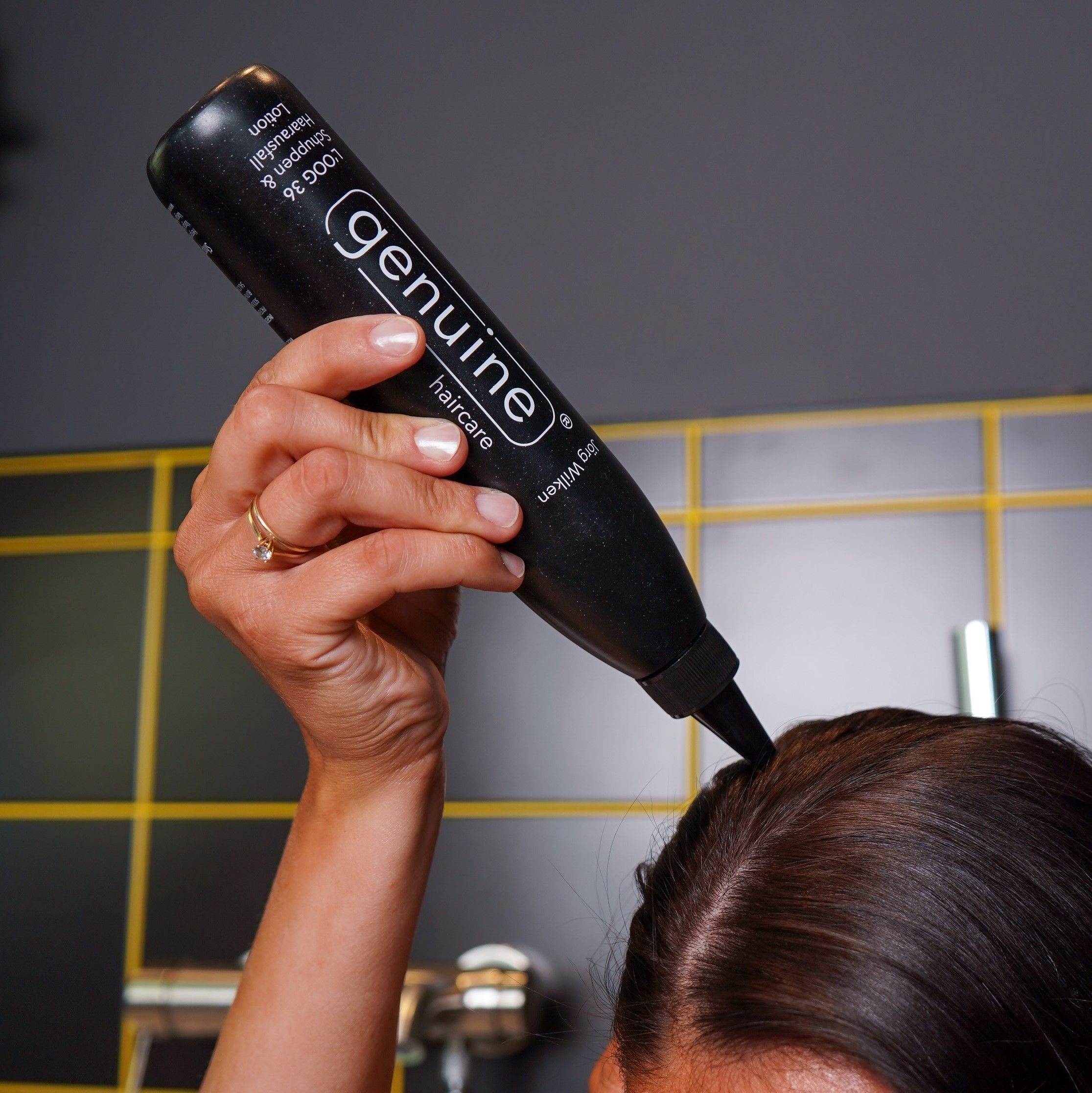 Schwarze Flasche mit Spitze, wird auf den Kopf gehalten. Aufschrift: genuine haircare, LOOG 36 Lotion.