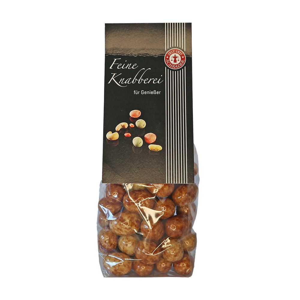 Klare Tüte mit Schrader Spekulatius-Mandeln. Schwarzes Etikett mit Schriftzug "Feine Knabberei".