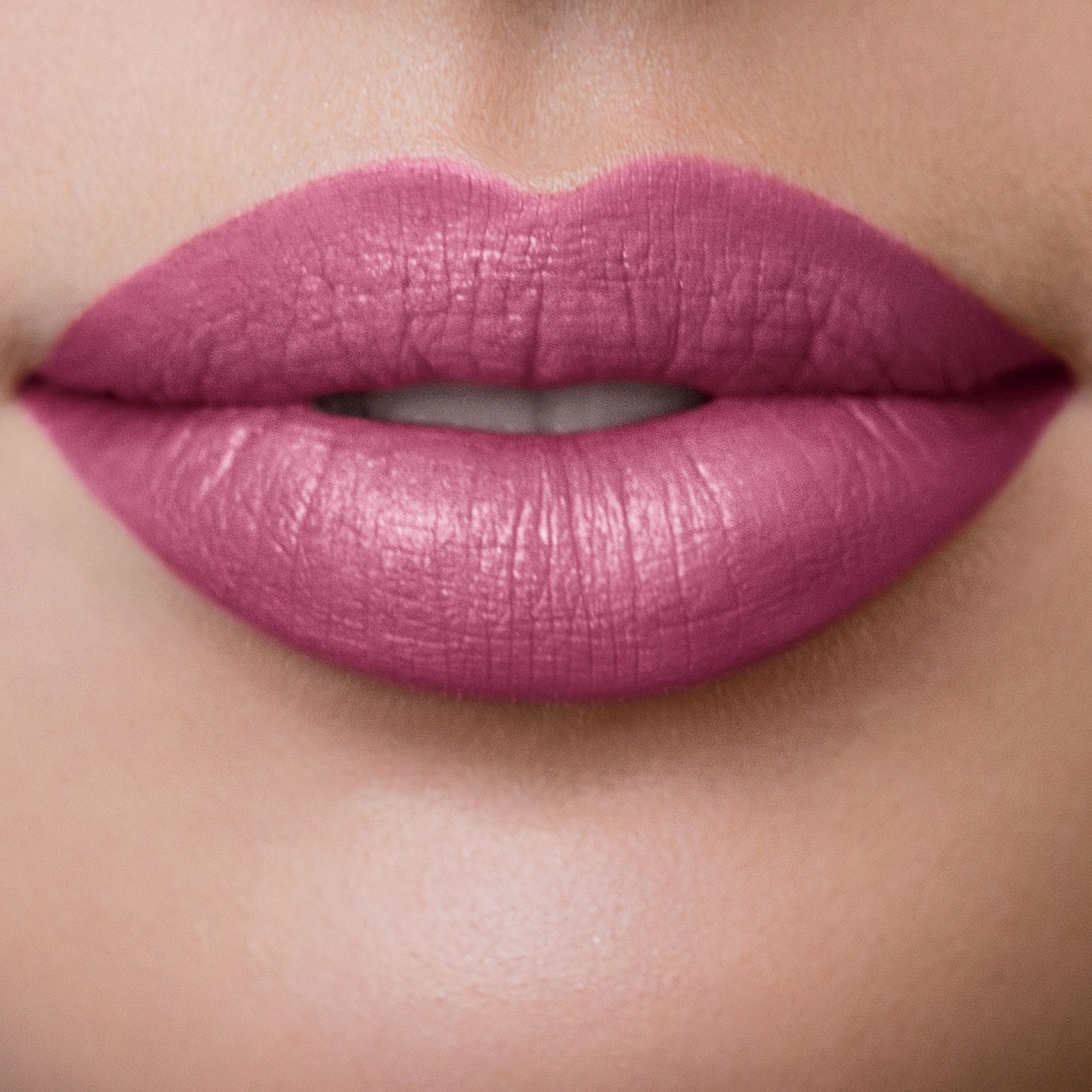Nahaufnahme von Lippen, die mit Tender Plum Lippenstift bemalt sind. Die Farbe ist ein dunkles Rosa.