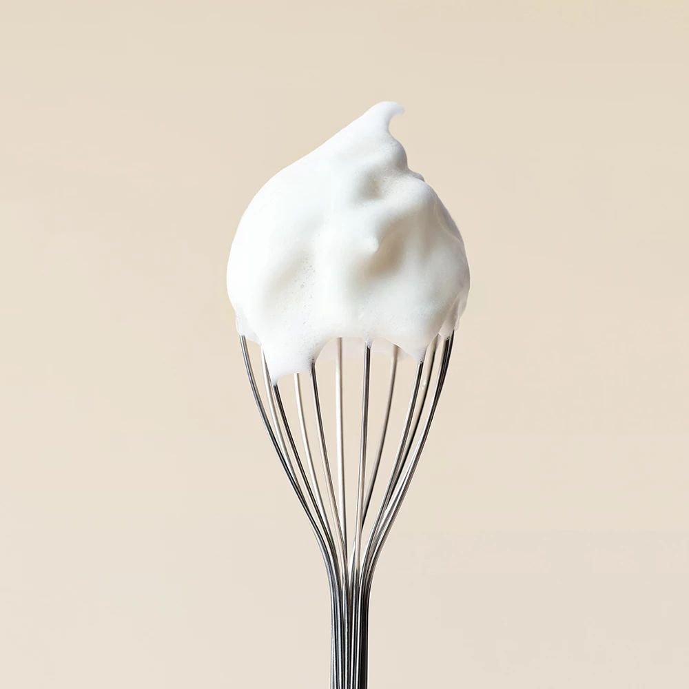 Ein Schneebesen mit einer Spitze aus weißem Reinigungsschaum.