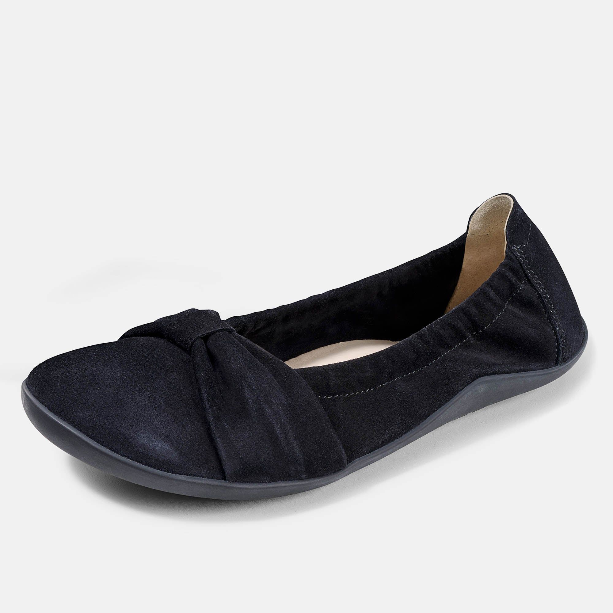 Schwarze Ballerina mit Schleife. Flache Sohle, Obermaterial aus Wildleder. Schuh leicht schräg gestellt.