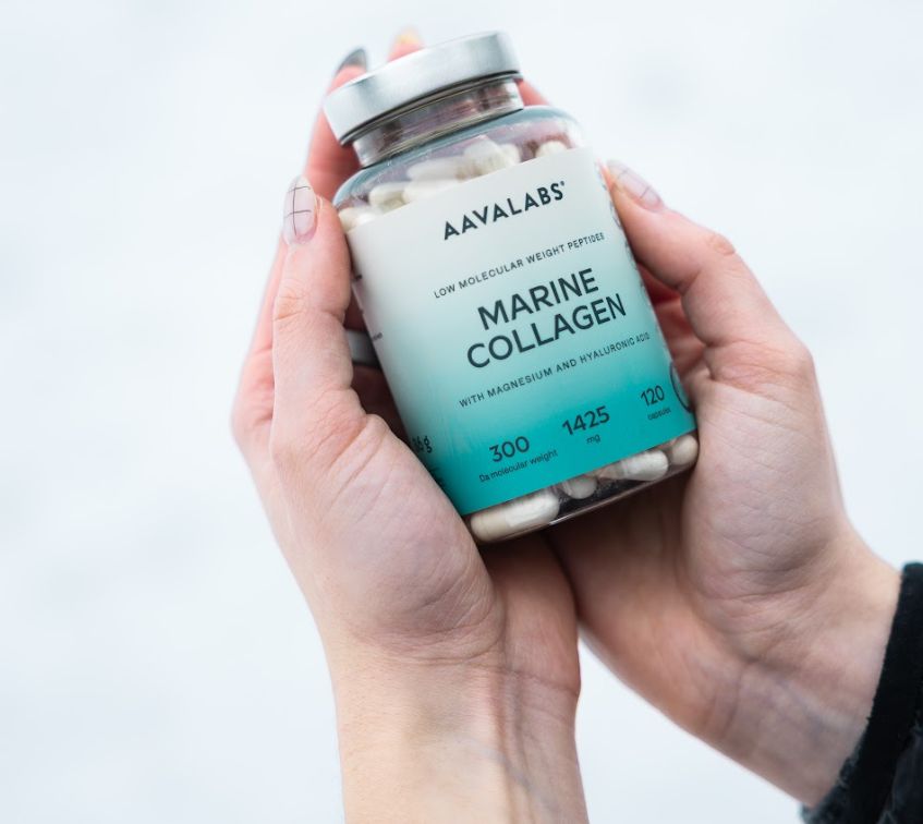 Hände halten eine Flasche Aavalabs Marine Collagen im Schnee.