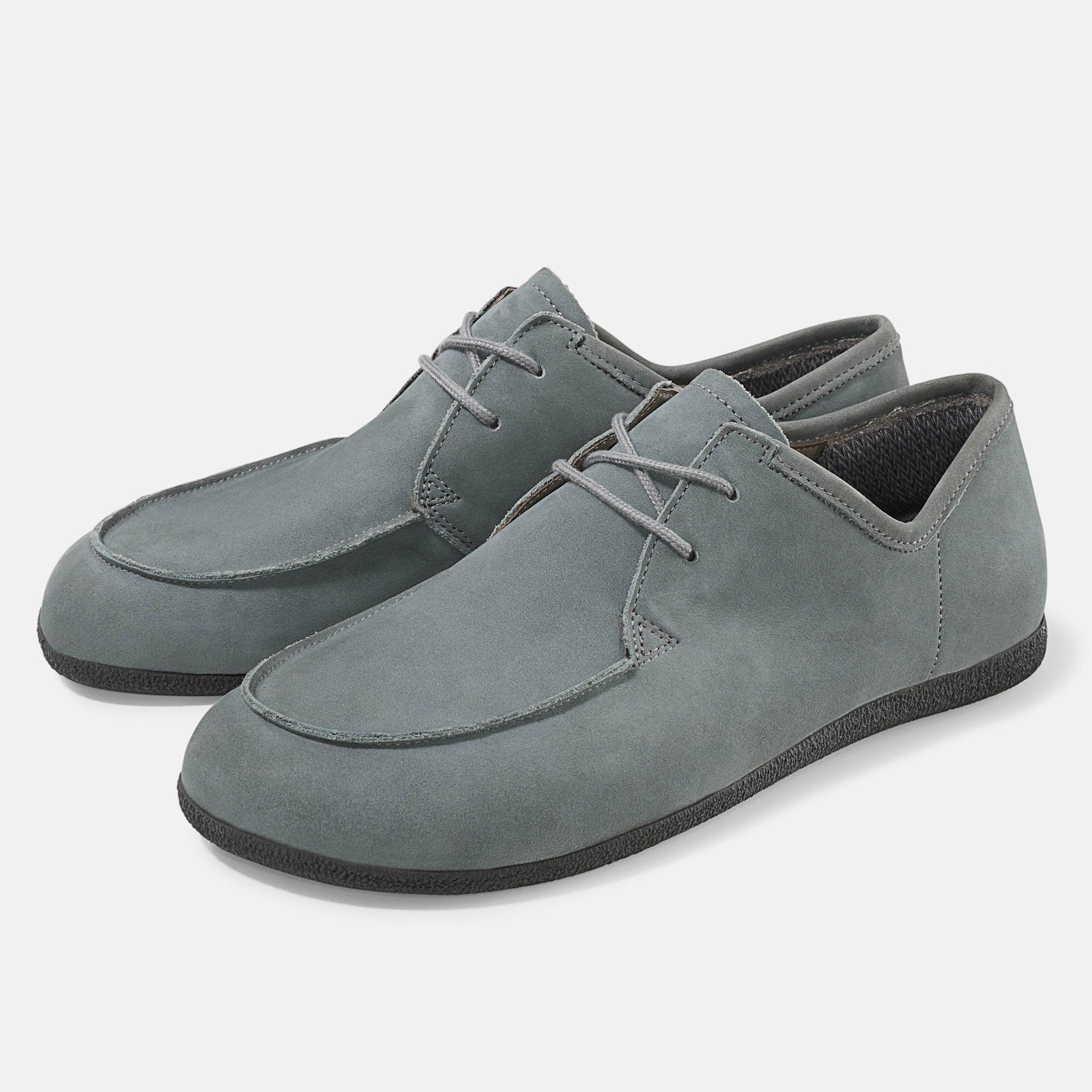 Graue Schnürschuhe. Flache Sohle, runde Spitze. Hellgraue Schnürsenkel. Zwei Schuhe nebeneinander.