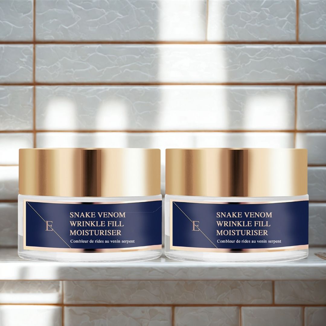 Zwei Tiegel mit goldfarbenen Deckeln und blauen Etiketten. Aufschrift: Snake Venom Wrinkle Fill Moisturiser. Auf einer weißen Ablage.