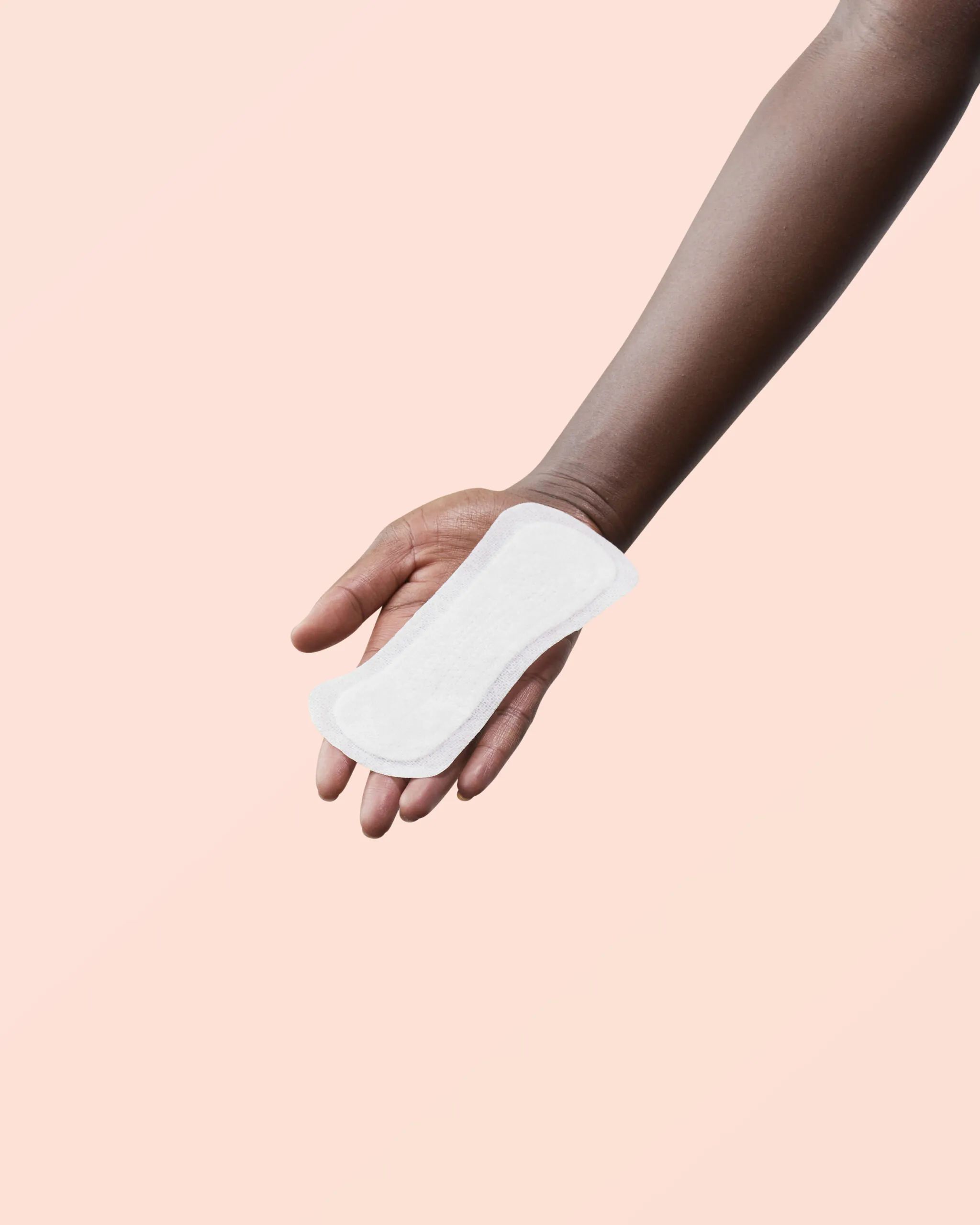 Weißes Slipeinlage in einer Hand. Auf rosa Hintergrund. Baumwolle. Normal.