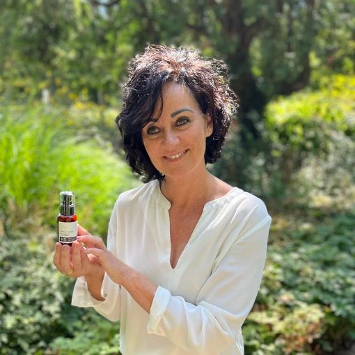 Frau hält Produktflasche. Anti-Wrinkle Face Cream. Braune Flasche mit Pumpe. Vegan, Bio.