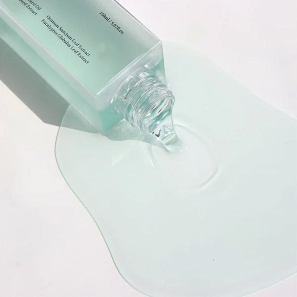 Nahaufnahme von Dr. Althea Gentle Pore Vegan Cleansing Oil, das aus einer Flasche auf eine Oberfläche gegossen wird.