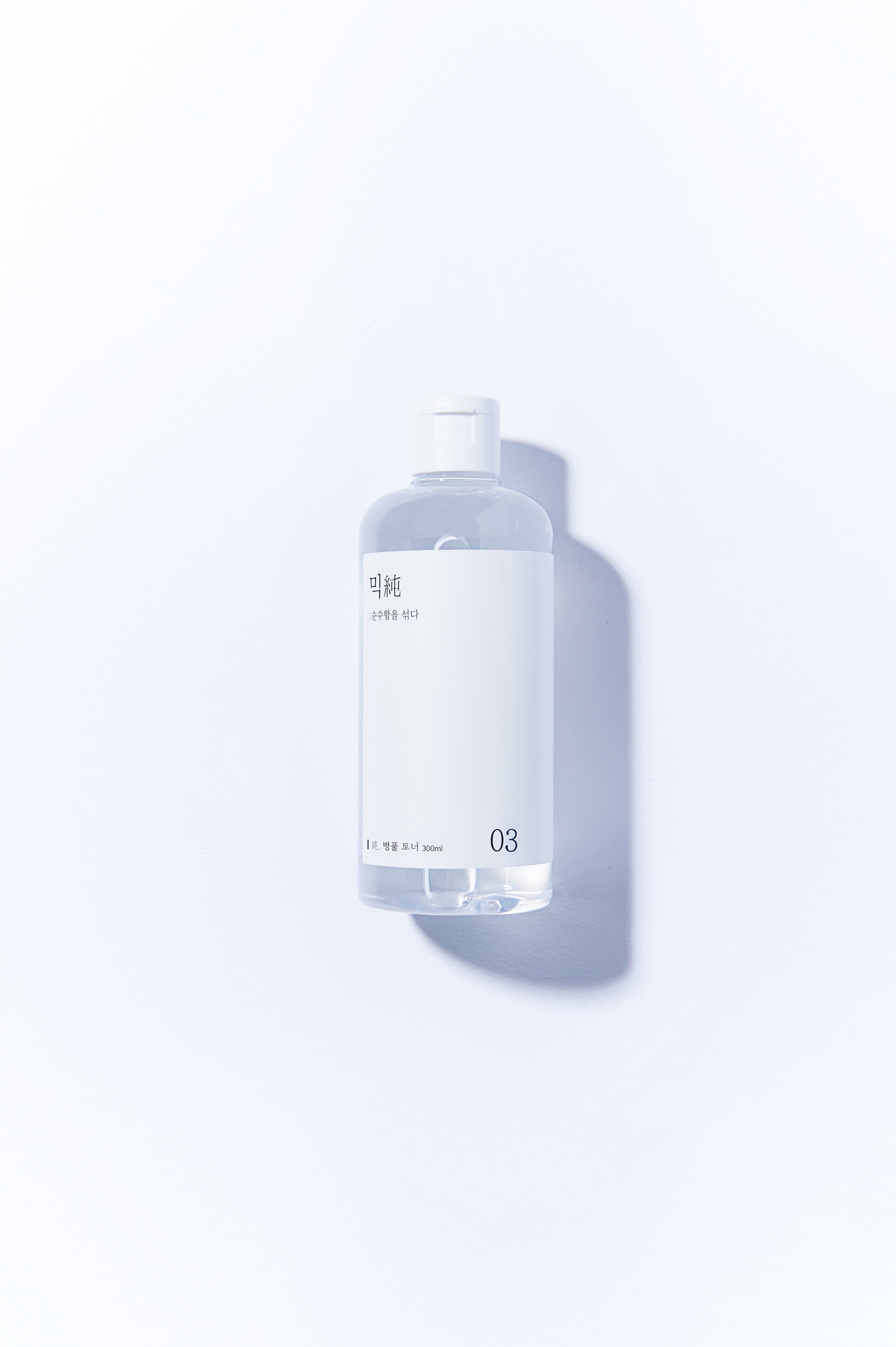 Transparente Flasche mit weißem Deckel und Etikett. Aufschrift in koreanischer Schrift und die Zahl 03. Aufschrift: 200ml.