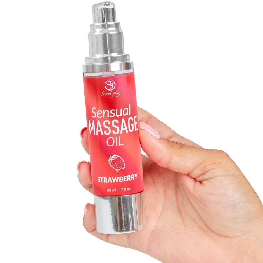 Rote Flasche mit silberner Pumpe. Aufschrift: Sensual Massage Oil Strawberry. Hand hält die Flasche.