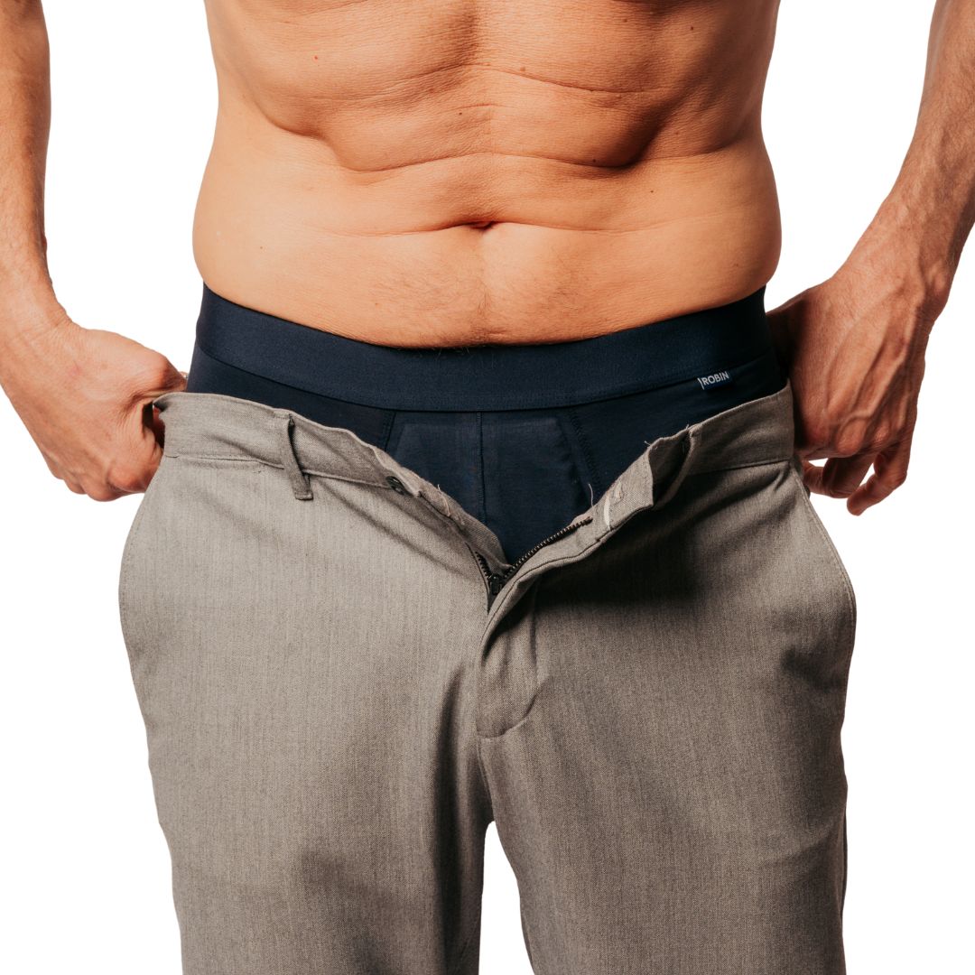 Dunkelblaue Boxer unter einer geöffneten Hose, Bund sichtbar.