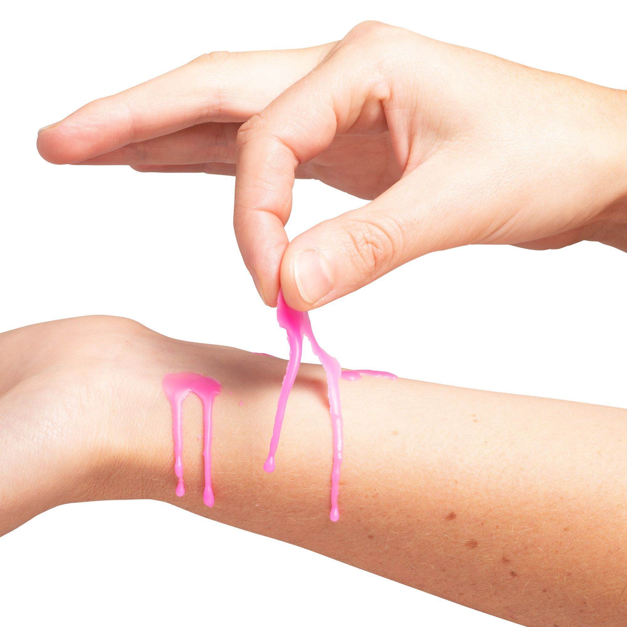 Eine Hand entfernt pinkfarbenes Wachs von einem Handgelenk. Wachs tropft vom Handgelenk.