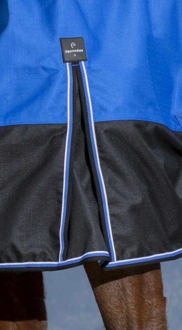 Nahaufnahme einer blauen und schwarzen Outdoordecke mit einem Etikett. Das Etikett trägt die Aufschrift Equitheme.