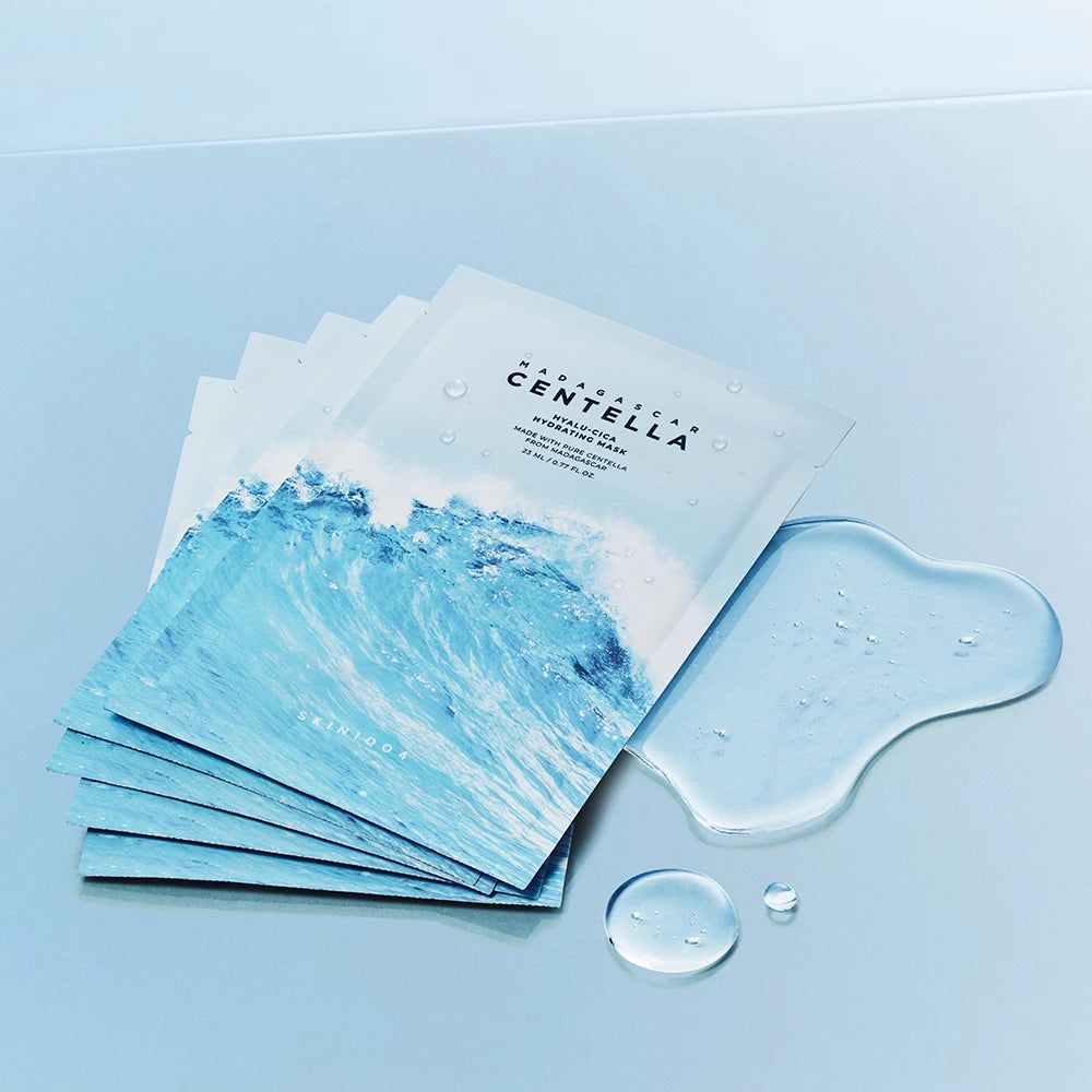 Fünf einzeln verpackte Gesichtsmasken mit Centella-Aufschrift und Wellendesign. Daneben ein Tropfen Serum.