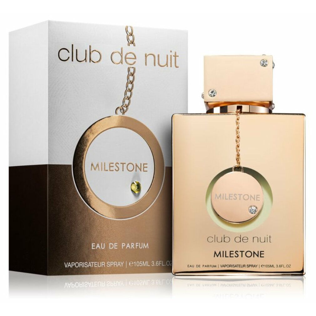 Goldfarbener Flakon mit weißer Verpackung. Aufschrift 'Club de Nuit Milestone'. Flakon mit Anhänger und Schmucksteinen.