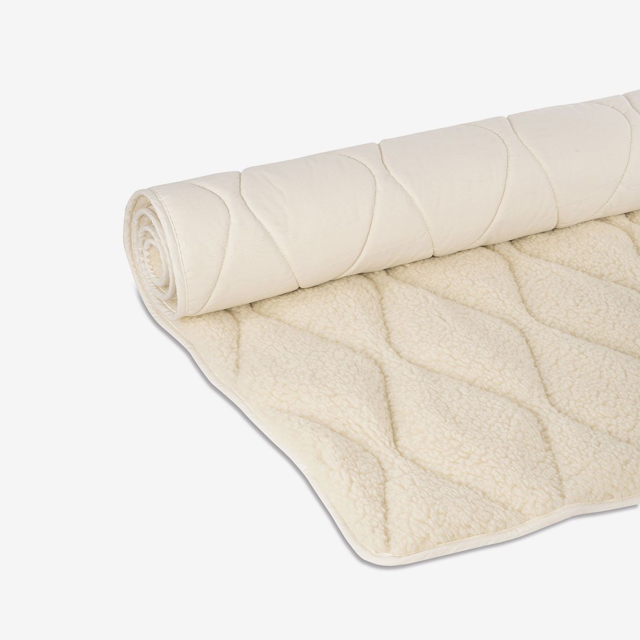 Gerollte Yogamatte aus Schurwolle, beige. Wellenförmiges Steppmuster, weißer Rand. Detailansicht.