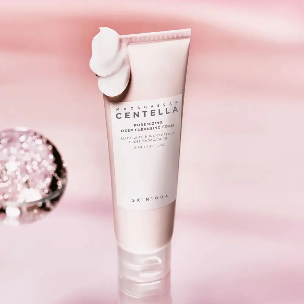 Rosa Tube mit Schaum. Text: MADAGASCAR CENTELLA, Poremizing Deep Cleansing Foam. Marke SKIN1004.