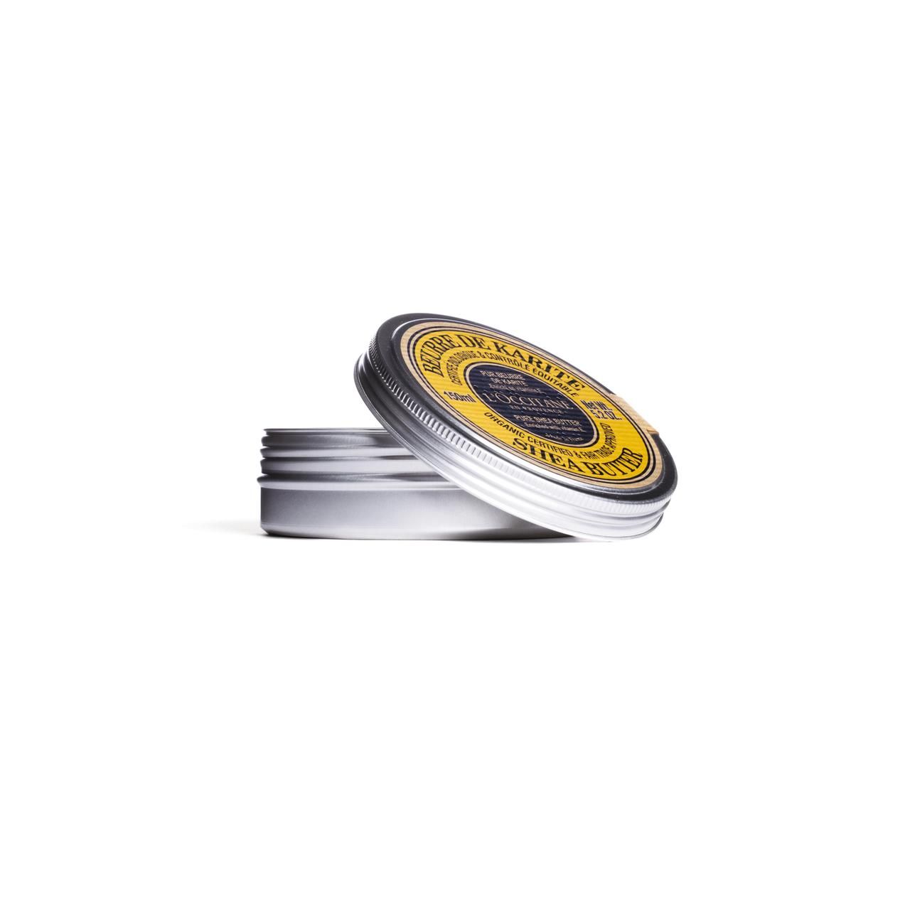 Geöffnete, silberfarbene Dose mit gelbem Deckel. Aufschrift: "Beurre de Karité", "Pure Shea Butter". Marke: L'Occitane.