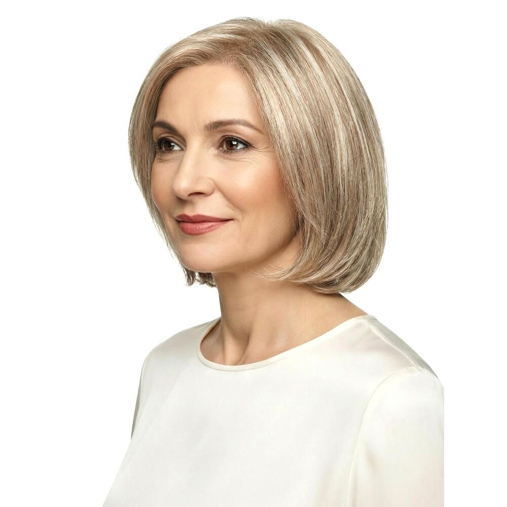 Perücke mit blonden Strähnen. Kurzer, kinnlanger Schnitt. Frau mit weißem Oberteil, Blick nach links.