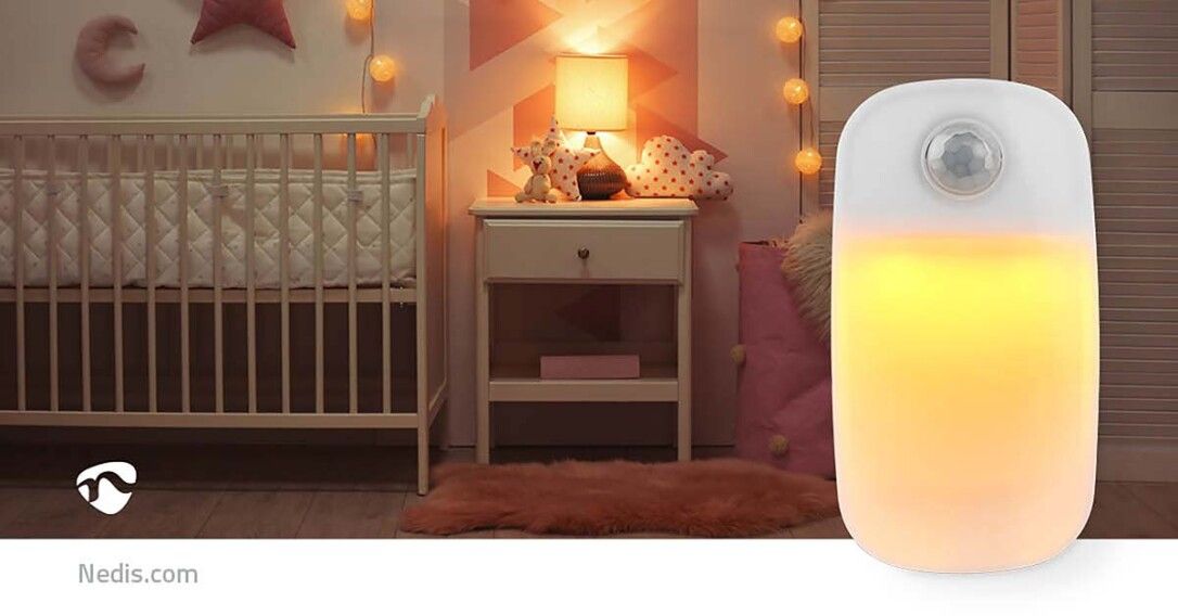 Nachtlicht mit Bewegungssensor. Weißes Gehäuse, gelbes Licht. Im Kinderzimmer, neben Wiege.