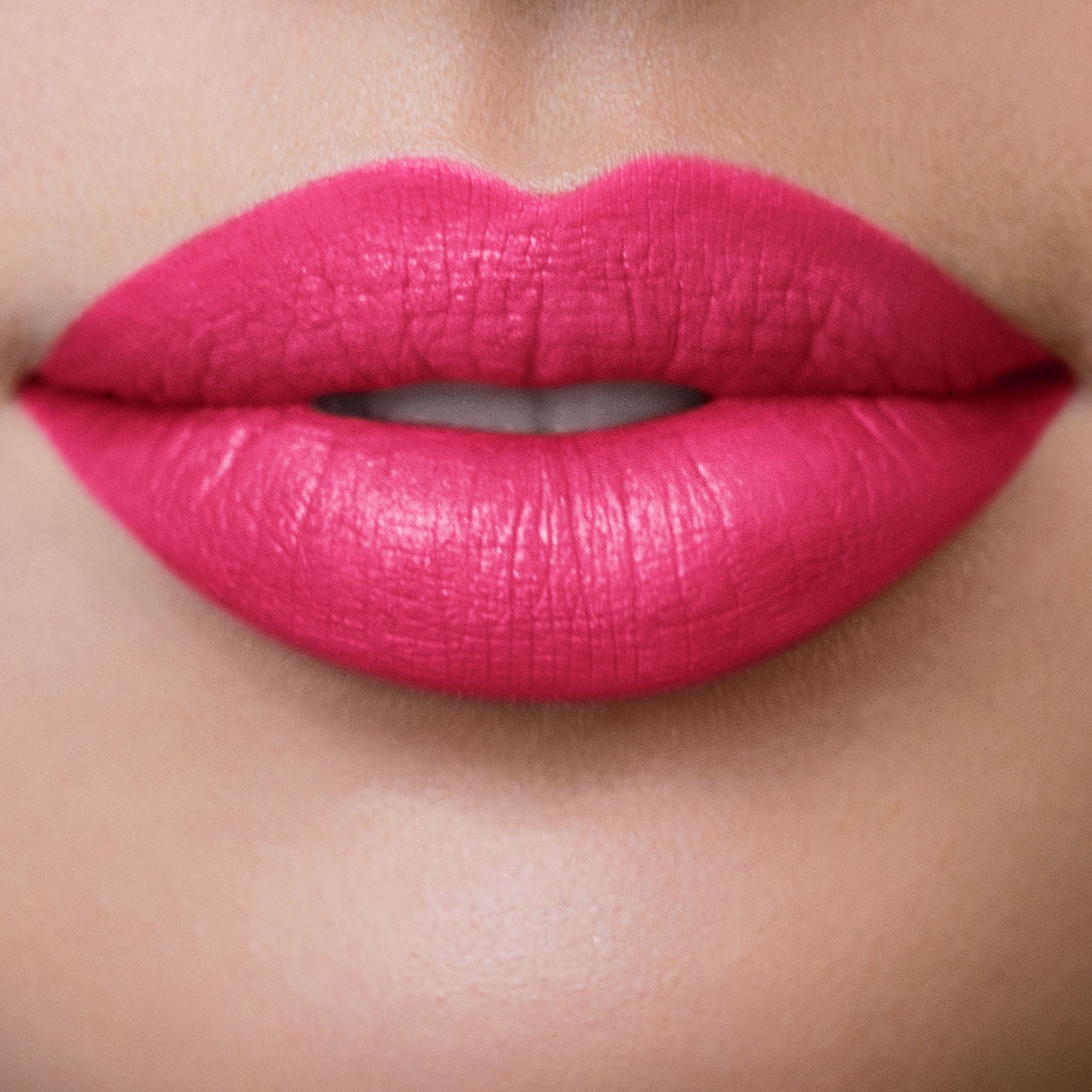 Nahaufnahme von Lippen, die mit pinkem Lippenstift geschminkt sind. Deutliche Lippenkonturen.
