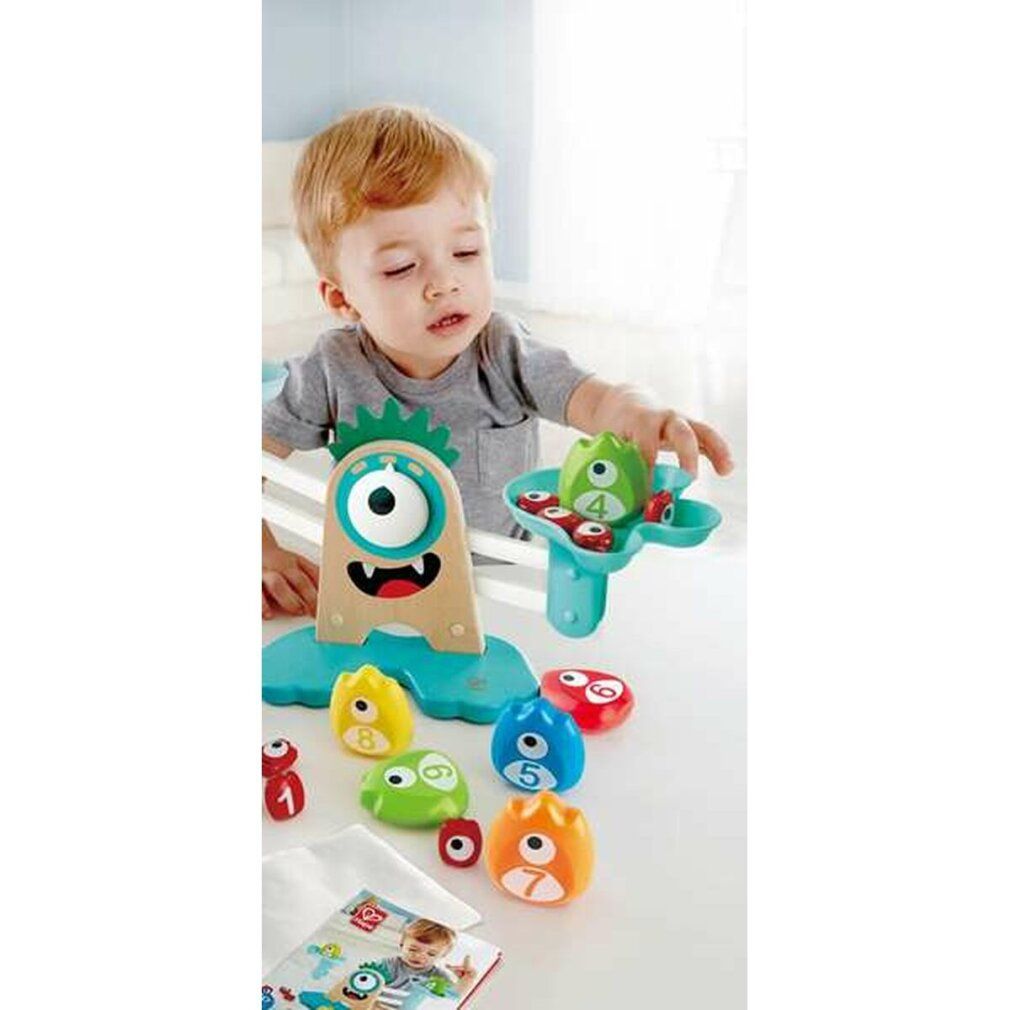 Kind spielt mit der Monster-Waage. Verschiedene farbige Gewichte und Zahlen.