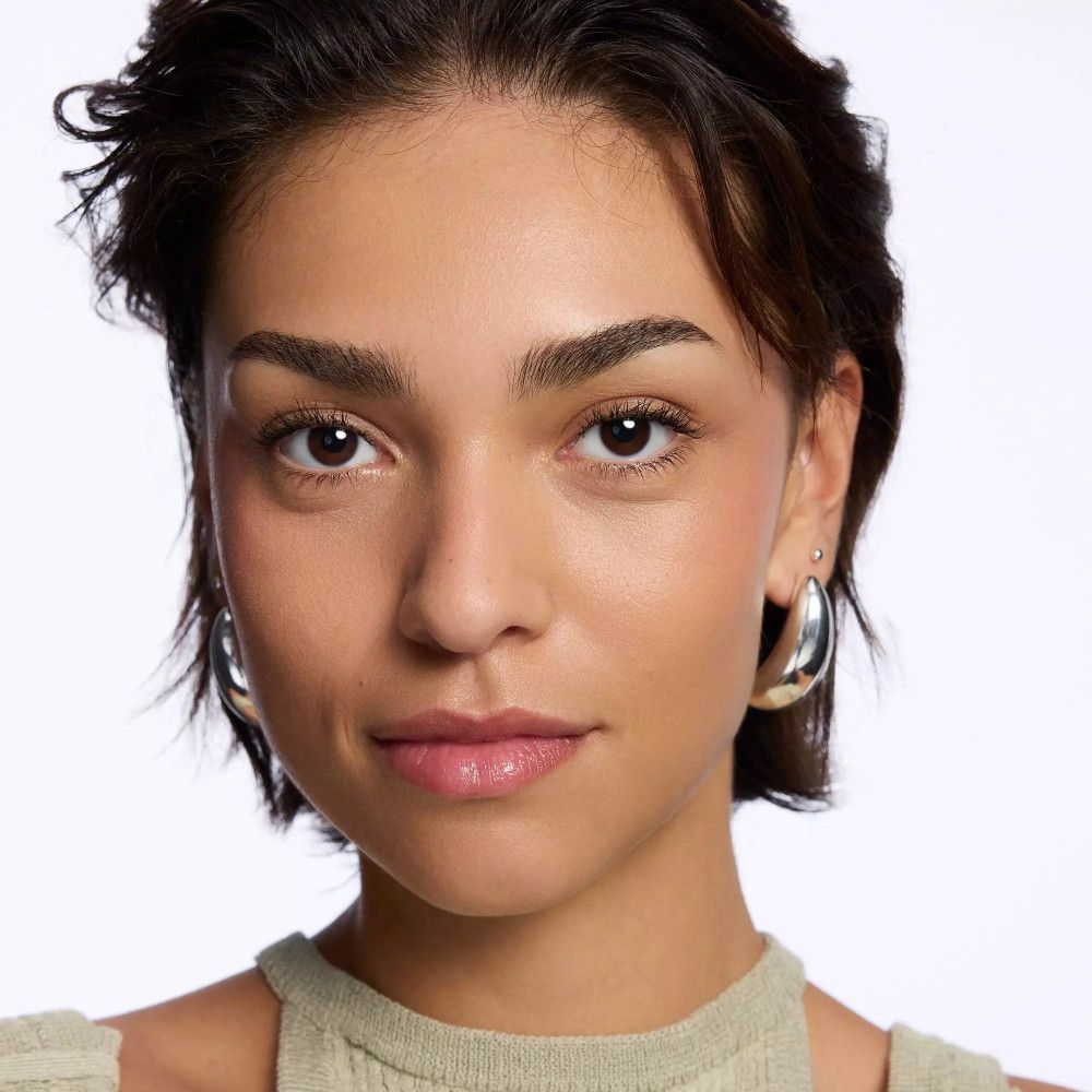 Porträt einer Frau mit hellem Teint. Sie trägt silberne Creolen. Lippen ungeschminkt.