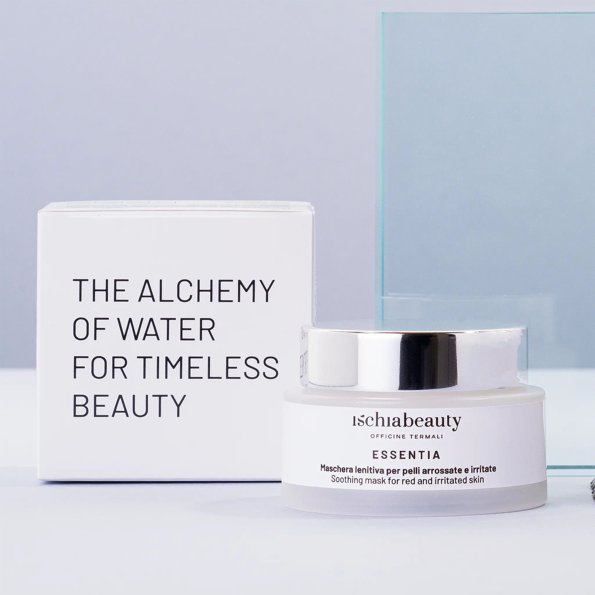 Creme-Tiegel neben weißer Schachtel. Aufschrift: ischiabeauty, ESSENTIA, Maschera lenitiva per pelli arrossate e irritate, Soothing mask for red and irritated skin.