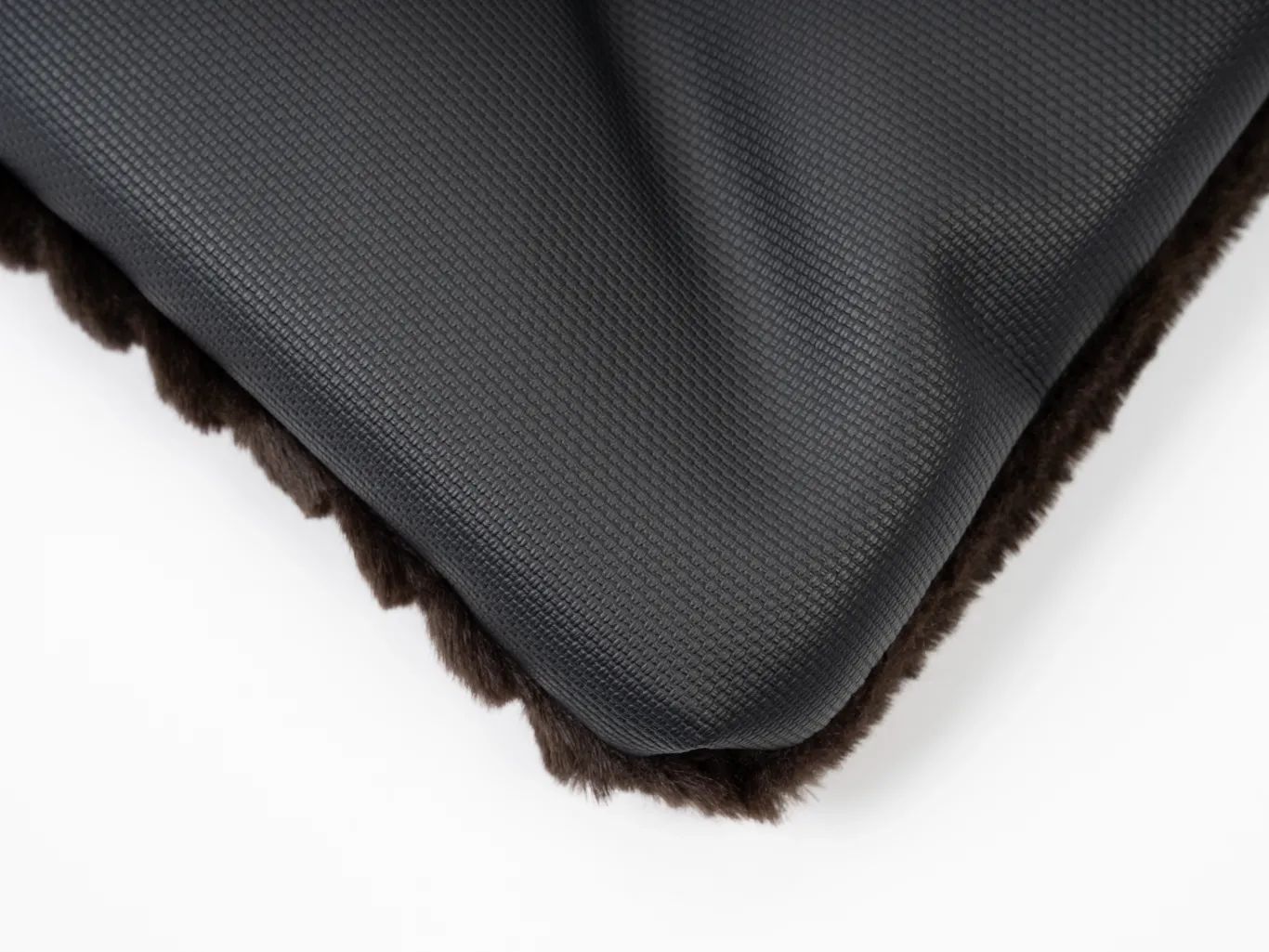 Ecke der gefütterten Liegedecke. Braune Oberseite, schwarze Unterseite. Nahaufnahme.