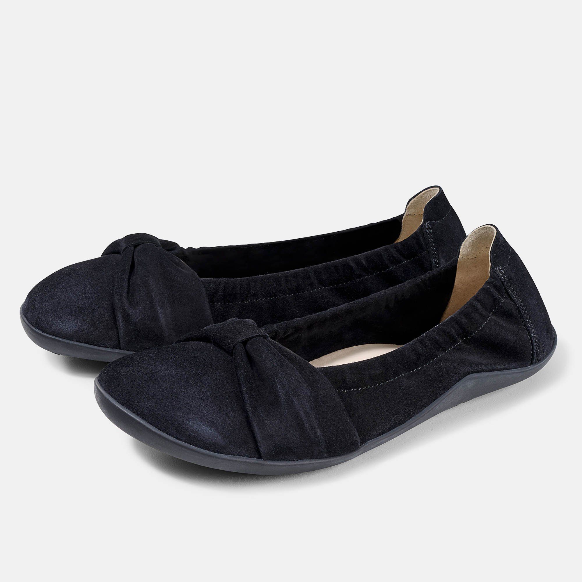 Schwarze Ballerinas mit Schleife. Weite Form. Zwei Schuhe nebeneinander, leicht von oben fotografiert.