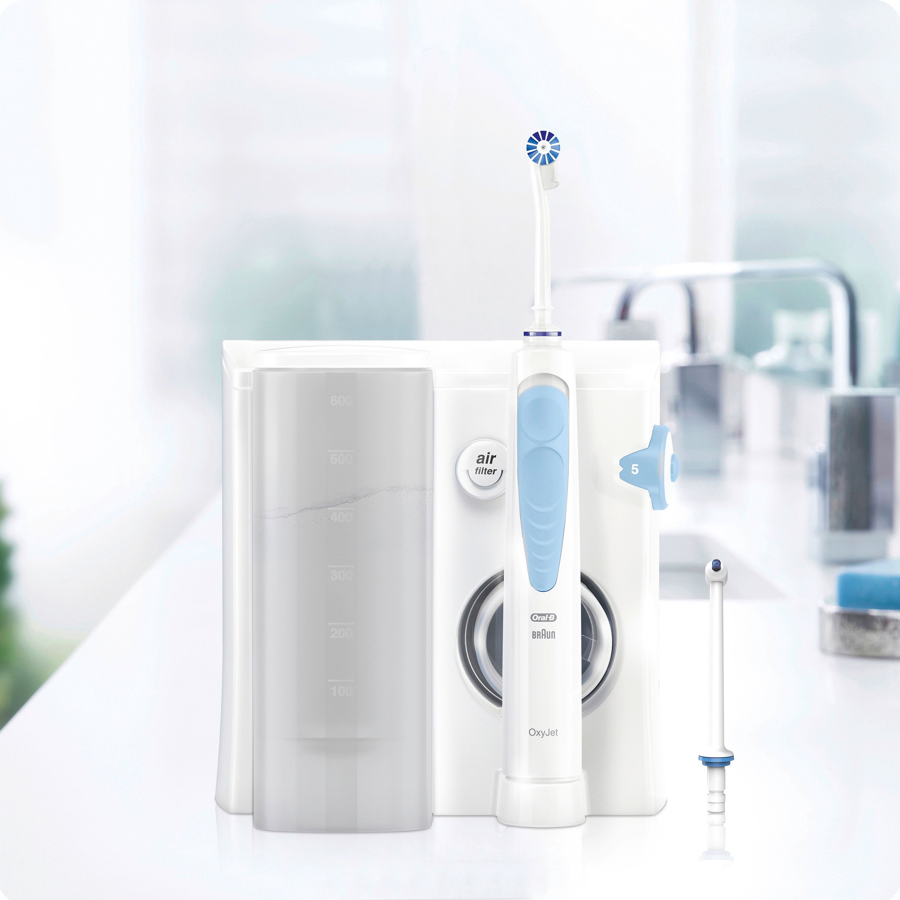 Oral-B Oxyjet Munddusche in Weiß. Gerät mit Zubehör auf weißer Oberfläche. Blaue und weiße Farbkombination.
