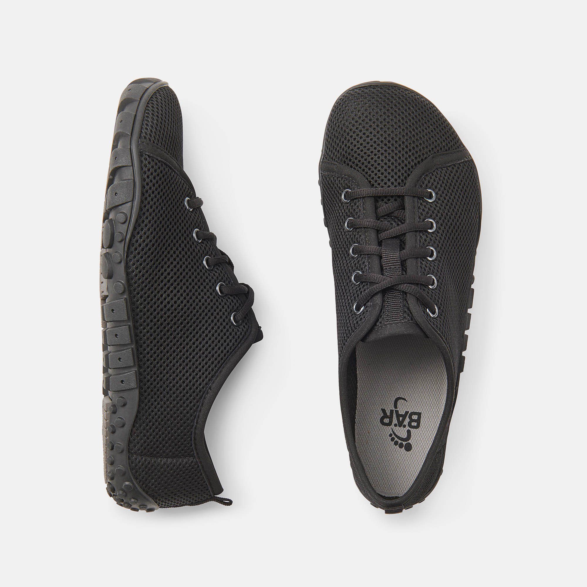 Zwei schwarze Herren-Schnürschuhe, breite Passform. Mesh-Obermaterial, Schnürsenkel. Sohle mit BÄR-Logo und Fußabdruck.
